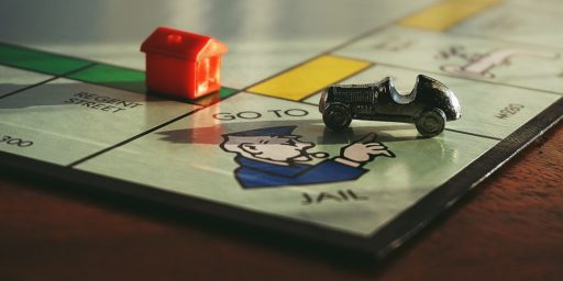Monopoly board Go Directly to Jail with car and hotel