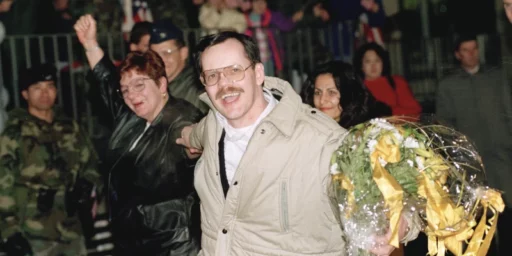 Terry Anderson, center, accompanied by his sister Peggy Say, left, and Madeleine Bassil, right, in Germany, Dec. 5, 1991. (AP Photo/Thomas Kienzle, File)