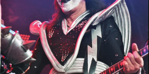 KISS lead guitarist Ace Frehley plays between Gene Simmons -L- and Paul Stanley -R- during the guitar exchange portion of the song DETROIT, ROCK CITY in Bakersfield, CA during the band's Farewell Tour, March 21, 2000.