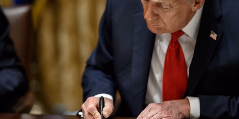 President Donald Trump signs a mineral agreement during a bilateral meeting with Australian Prime Minister Anthony Albanese in the Cabinet Room, Monday, October 20, 2025.