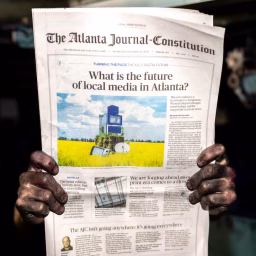 An employee with ink-stained hands poses with a final print edition of The Atlanta Journal-Constitution at the printing press at Metro Market Media in Gainesville on Tuesday, Dec. 30, 2025. It was the final print run for The Atlanta Journal-Constitution, after 157 years.